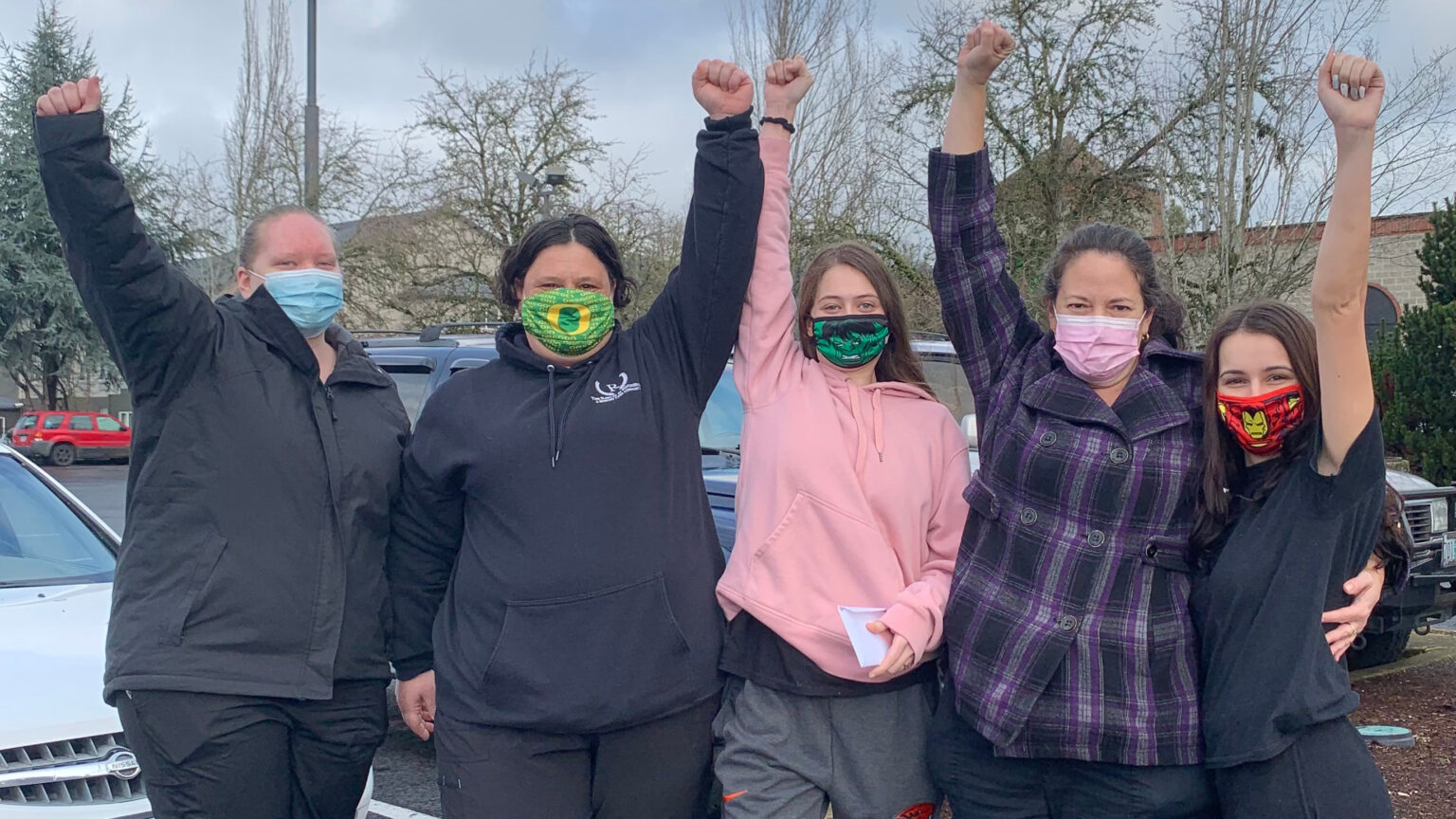 5 Rawlins workers shown wearing masks with their fists in the air